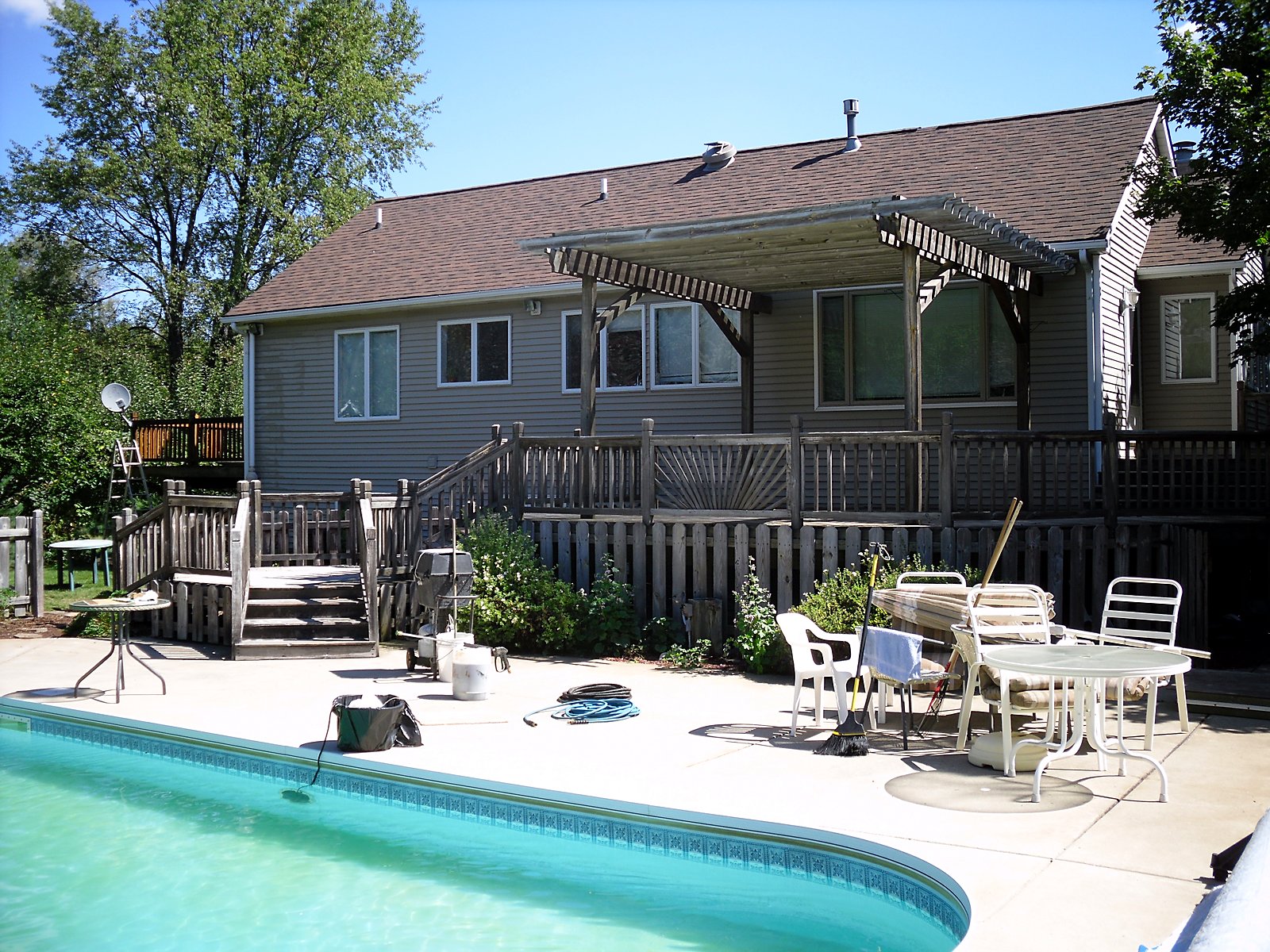 Weathered deck by the pool, before restoration in Northville, MI