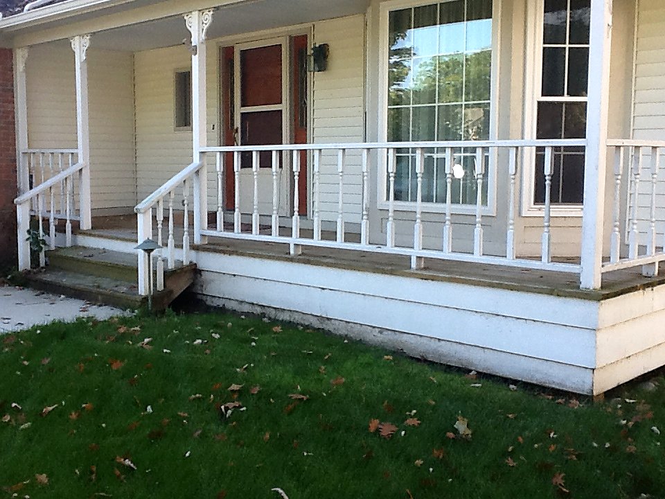 Weathered porch railing before restoration in Hartland, MI
